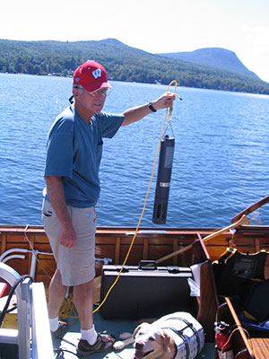 Limnologist-holding-sonde-with-mountains.jpg